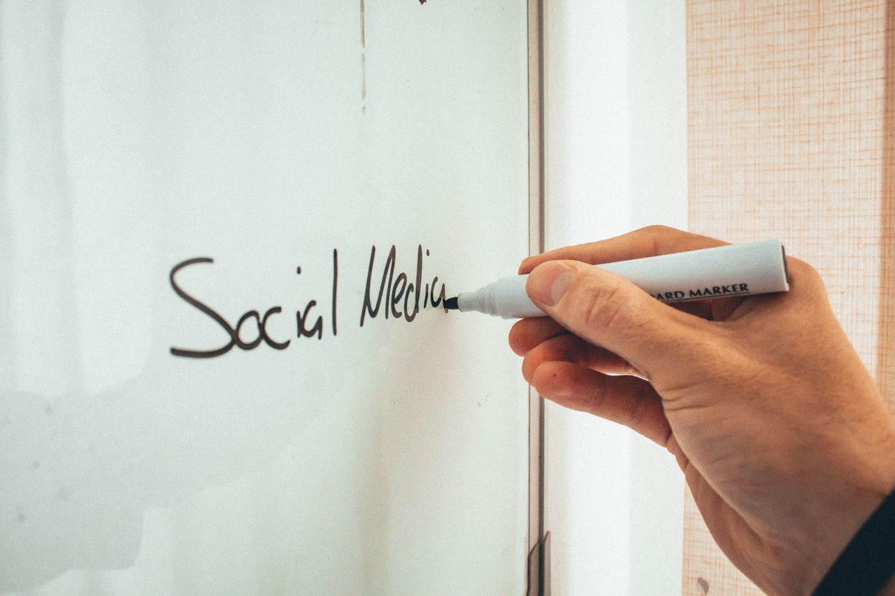 services-01 Cropped anonymous male instructor writing on a whiteboard with a marker during social media training courses