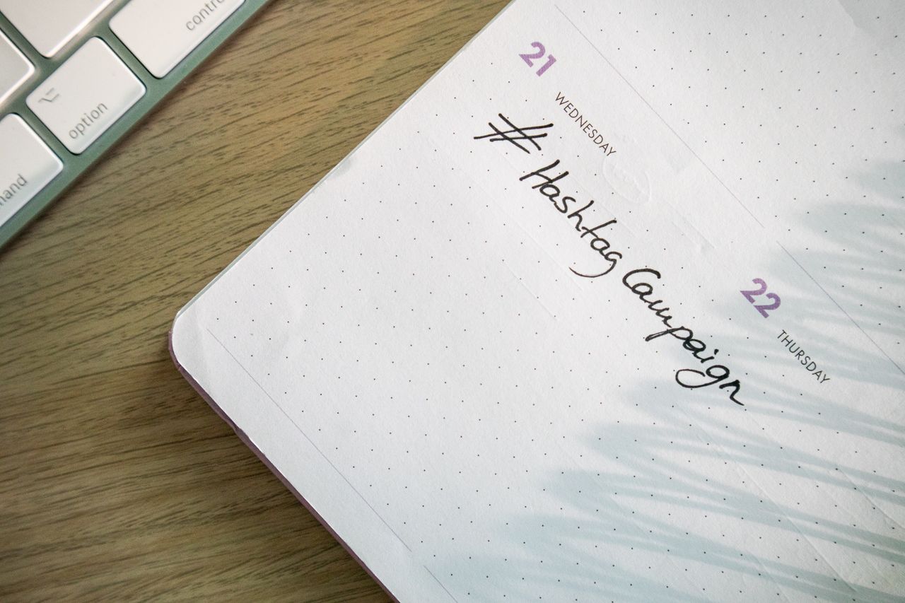 services-03 Open planner with Hashtag Campaign handwritten next to keyboard. Ideal for social media and productivity themes.